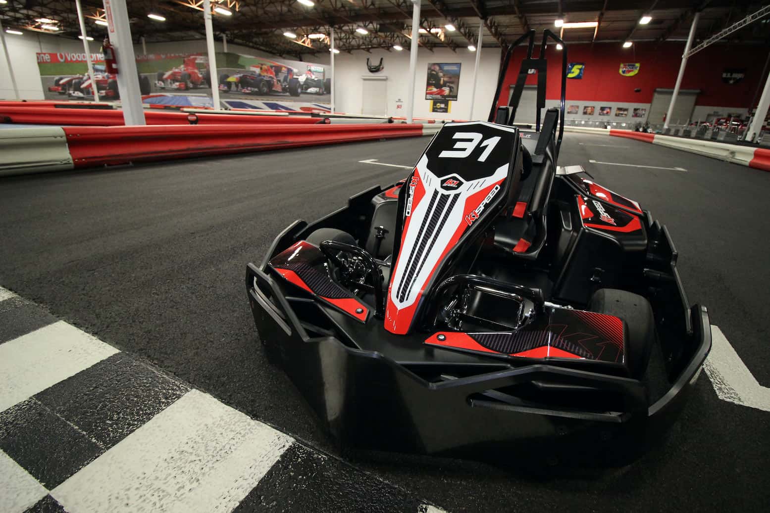 a go kart sits on a k1 speed track with protex barriers