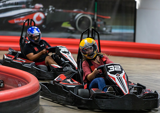 two people go kart racing inside k1 speed